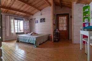 1 dormitorio con 1 cama en una casa de madera en B&b Ventuno IUN0058, en Barumini