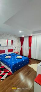 1 dormitorio con cama azul y cortinas rojas en Lake View Mall en Bacău