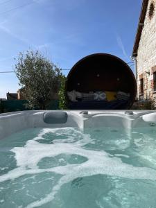 a bath tub filled with water with a bed at La couette du voyageur in Wanze