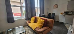 a living room with a couch with yellow pillows at City Blessed Aptm 5 with free parking in South Shields