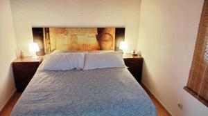 Mi habitación de invitados في بويرتو ديل روزاريو: غرفة نوم بسرير كبير مع مواقف ليلتين