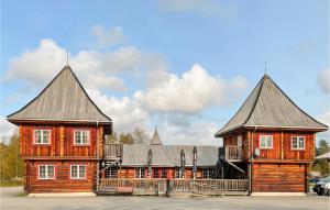 un gran edificio de madera con dos grandes techos en Pet Friendly Home In Grue Finnskog With Wifi en Svullrya