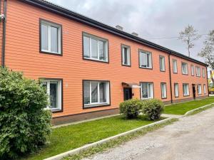 a large orange building with a street in front of it at Lovely and quiet condo in Kristiine. Free parking. in Tallinn
