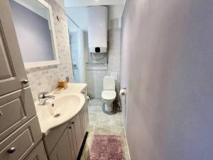 a white bathroom with a sink and a toilet at Lovely and quiet condo in Kristiine. Free parking. in Tallinn