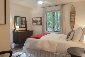 een slaapkamer met een wit bed en een raam bij Northwoods Resort in Woodruff