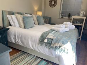 a bedroom with a bed with towels on it at The Courtyard Rooms in Brightlingsea