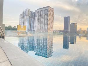 a large swimming pool with buildings in the background at KL Dua Sentral Dreamy Stay Studio in Kuala Lumpur