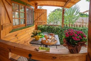 a wooden patio with a table with food and flowers at B&b Ventuno Barumini in Barùmini