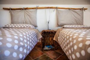 1 dormitorio con 2 camas y suelo de baldosa en Il Faggio, en Villar San Costanzo