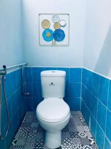 Habitación con suelo de baldosa azul y baño con aseo. en SOFEA HOMESTAY en Pantai Cenang