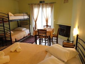 ein Zimmer mit 2 Etagenbetten und einem Esszimmer mit einem Tisch in der Unterkunft Guesthouse Eleftherios in Kalavryta