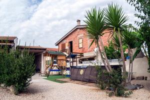 a house with a palm tree in front of it at B&b Ventuno IUN0058 in Barùmini