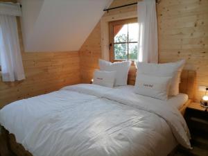 a bedroom with a large white bed with a window at Lärchenhaus ,,Unterer Brodl" in Kammersberg