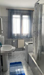 a bathroom with a tub and a sink and a bath tub at Rose e Frutta ristrutturato con parcheggio in Ronchi dei Legionari