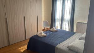 a bedroom with a blue bed and a white chair at Rose e Frutta ristrutturato con parcheggio in Ronchi dei Legionari