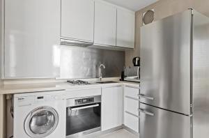una cocina con nevera de acero inoxidable y armarios blancos en Comfortable 1Bedroom 1Bath apartment in Singapore! en Singapur