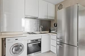 una cocina con nevera de acero inoxidable y armarios blancos en Comfortable 1Bedroom 1Bath apartment in Singapore! en Singapur