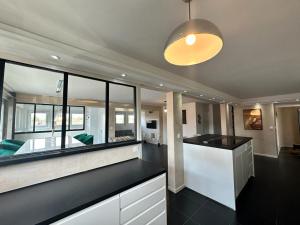 a kitchen with a black counter top and a large window at L'Élégant in Douvaine +9 photos