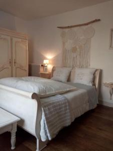 a bedroom with a large white bed with two pillows at House at the foot of the castle of Fougeres in Fougères