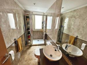 ein Badezimmer mit zwei Waschbecken, einem WC und einer Dusche in der Unterkunft Apartamento Hugu in Oviedo