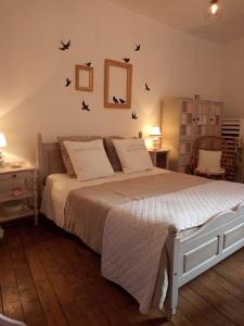 a bedroom with a bed with birds on the wall at House at the foot of the castle of Fougeres in Fougères