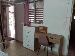 a desk with a chair and a window in a room at Nature in Fort-de-France