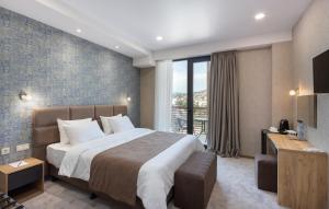 - une chambre avec un grand lit et une grande fenêtre dans l'établissement Brooch Boutique Hotel, à Tbilissi
