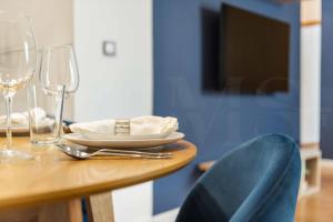 - une table en bois avec une assiette et des verres à vin dans l'établissement Inviting apartment in the center by REMS, à Malaga