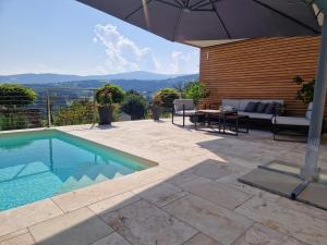 a patio with an umbrella and a swimming pool at Gästezimmer in den Weinbergen - exquisit und ruhig - mit Self-Check-in in Sankt Stefan ob Stainz