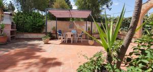 a patio with a table and chairs under a canopy at Villa Paola appartamento completo in Ciminna