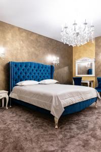 a bedroom with a blue bed and a chandelier at Zhytomyr palace mimino in Zhytomyr