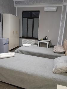 Cette chambre comprend 2 lits et une fenêtre. dans l'établissement Delfin Guest House, à Gandja