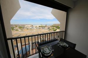 balcón con mesa y vistas a la calle en Studio Indecent, en Cap d'Agde