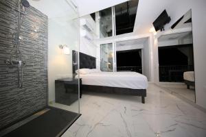 1 dormitorio con 1 cama y pared de cristal en Studio Indecent, en Cap d'Agde