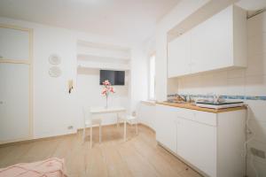 代森扎諾－德爾加達的住宿－Suite "Castello" del Garda - APT per coppie Garda，厨房配有白色橱柜和小桌子