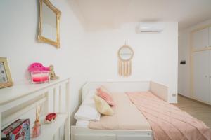 um quarto branco com uma cama com almofadas cor-de-rosa em Suite "Castello" del Garda - APT per coppie Garda em Desenzano del Garda