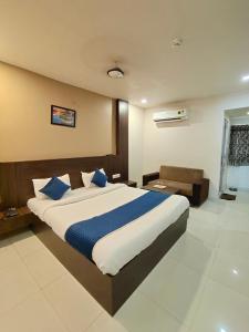 a bedroom with a large bed with blue pillows at Hotel Palav Palace in Ahmedabad