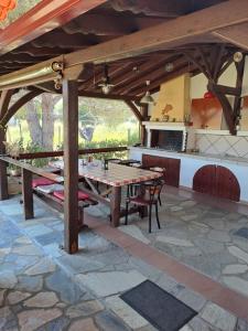 a patio with a wooden table and a kitchen at Konaki Guesthouse in Ormos Panagias
