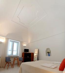 a white room with a bed and a window at L'Archetto romantic suite in the center of Anacapri in Anacapri
