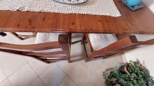 einen Esstisch aus Holz und Stühle mit einem Tisch in der Unterkunft Casa Vacanze Sa Rocca Tunda- Putzu idu- sardegna in Putzu Idu