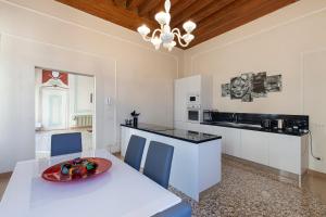 a kitchen with a white table and blue chairs at LUXURY APARTMENT PESARO PAPAFAVA in Venice
