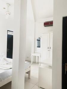 a white room with two beds and a mirror at Changami Residence in Nugegoda