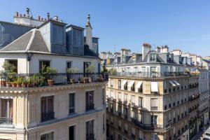 un groupe de bâtiments avec des plantes sur leur balcon dans l'établissement Hôtel Emile Le Marais, à Paris