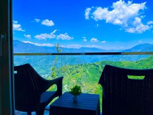 a table with a plant on top of a room with a view at Pinerock Resort, Mussoorie ! Luxury Rooms ! Mountain View ! Open Terrace ! Cafe in Mussoorie