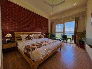 1 dormitorio con 1 cama grande y pared de ladrillo en Pinerock Resort, Mussoorie ! Luxury Rooms ! Mountain View ! Open Terrace ! Cafe, en Mussoorie