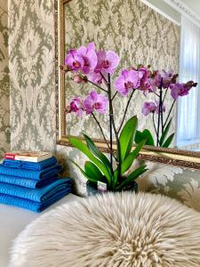 a vase of purple flowers in front of a mirror at Petřín No. 1 in Karlovy Vary