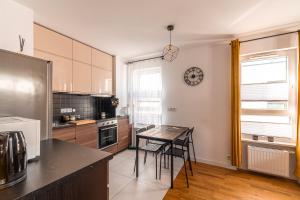 a kitchen with a table and a clock on the wall at Apartament Chmielna Loft in Kraków