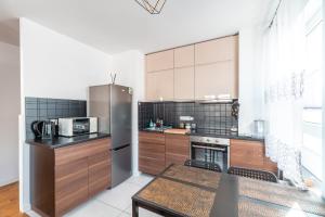 een keuken met een roestvrijstalen koelkast en een tafel bij Apartament Chmielna Loft in Krakau +4 foto's