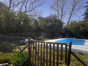 a wooden fence in front of a swimming pool at Cabañas lavanda in Tandil