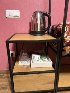 a black shelf with a tea kettle on it at Комната Gold Rose in Chişinău